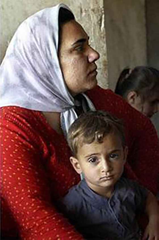 A woman and child seek care from a USAID-funded mobile women’s-health work team in Tewala Village, Iraq.
